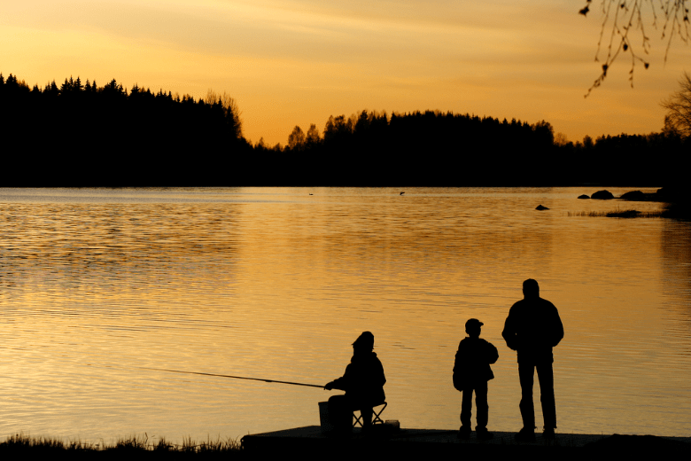 Three people fishing at sunset