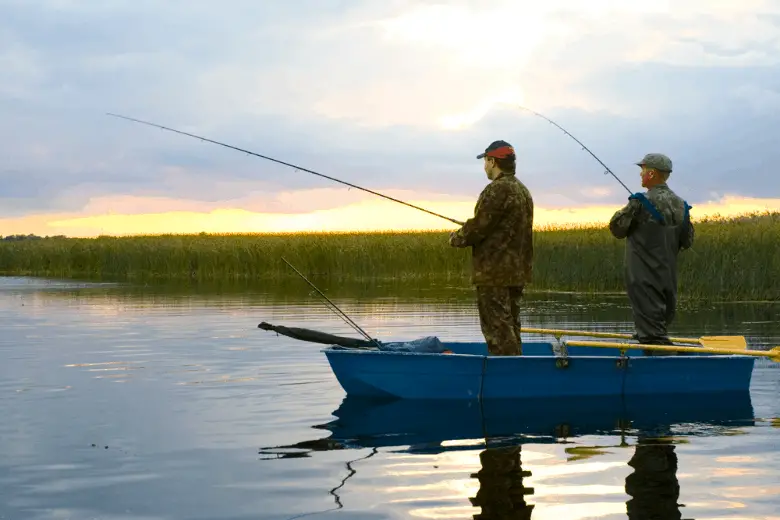 Two fishermen fishing from a boat