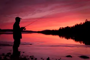 Man casting a reel at night