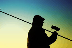 Fisherman with a fishing rod and spin reel in his hands