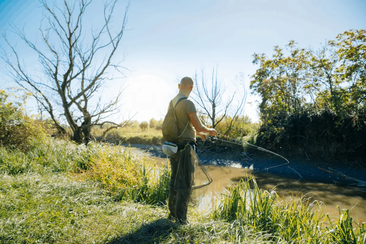 About a man fishing on a river.