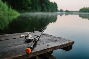 Fishing rod, spinning reel on the background pier river bank