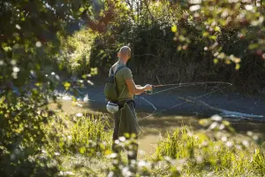 A man Spin fishing on a river