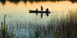 Fisherman on a lake at sunset