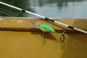 crankbait lure on a fishing pole placed on boatside