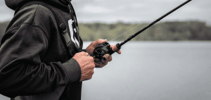man holding a fishing pole with baitcaster reel
