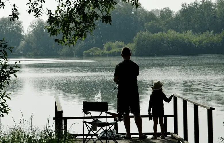 el hombre y su hijo están pescando en el lago
