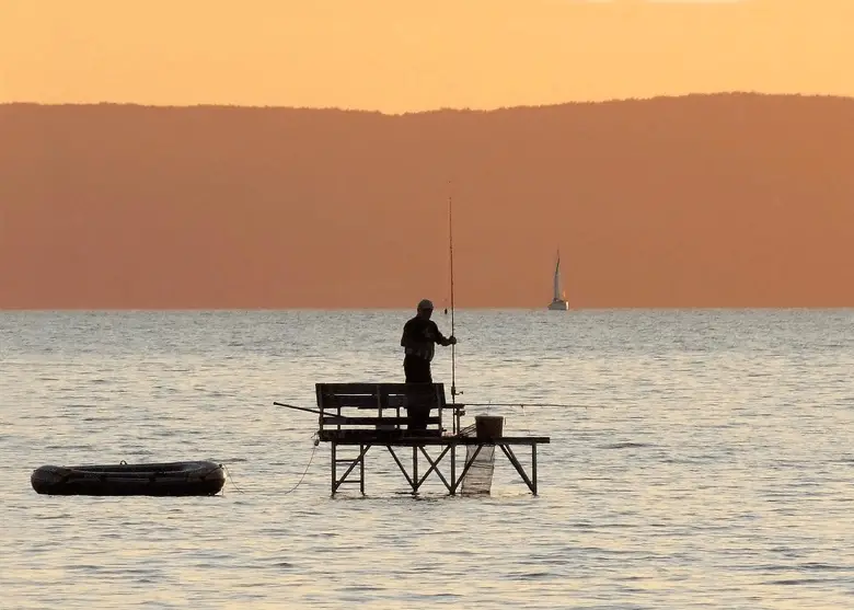 hombre pescando solo al atardecer