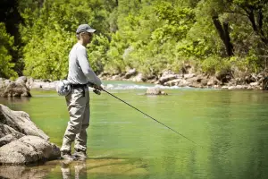angler fishing from the river bank on a sunny day