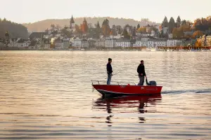 two anglers on a fishing boat in the middle of a lake