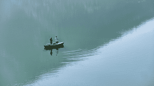 two anglers in a fishing boat in the middle of the lake