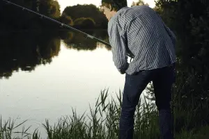 angler fishing from the river bay