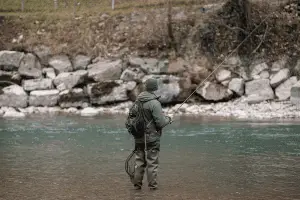 angler standing in the river fishing