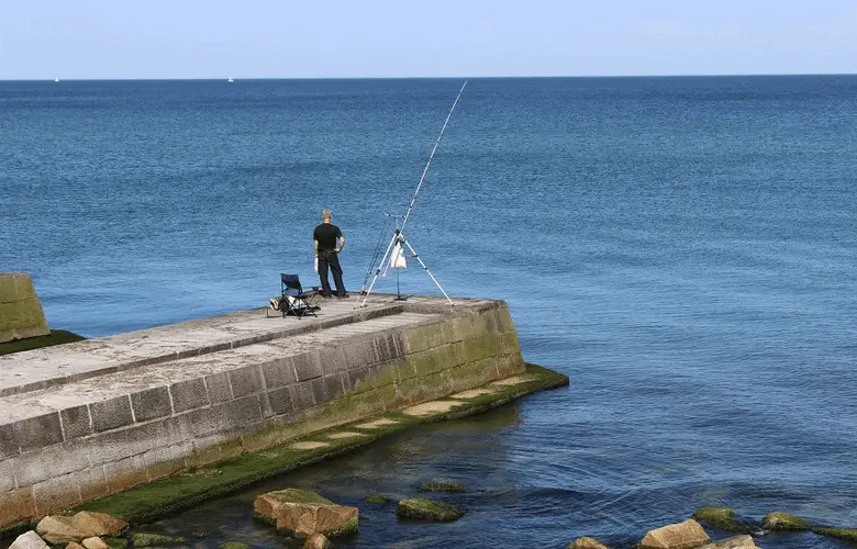 pescadores pescando desde un muelle de hormigón