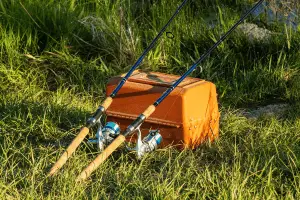 two fishing reel resting on a fishing kit box