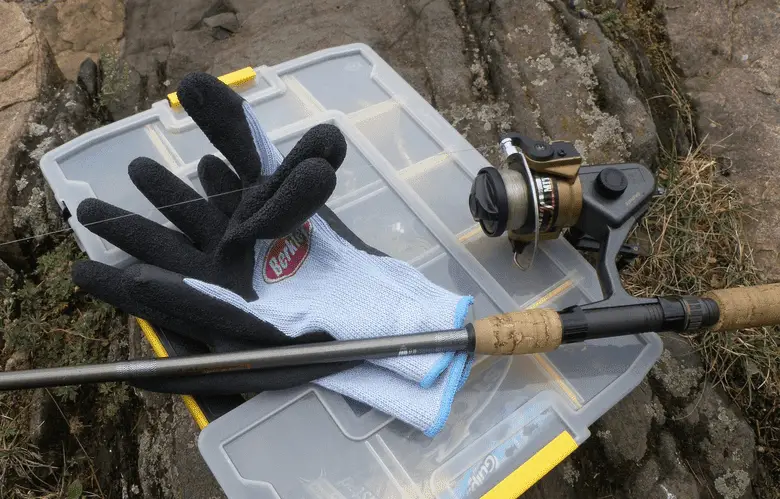 fishing reel and gloves on a fishing box