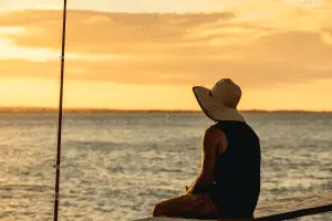angler sitting at the dock on sunset