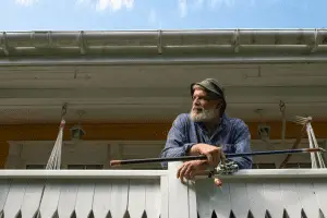 angler standing over the perch with his fishing reel