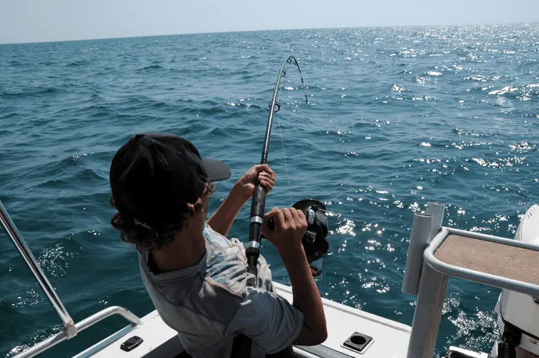 angler pulling a fishing rod from a boat