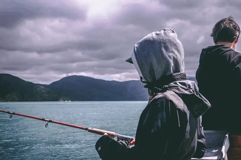 hombre con capucha pescando en un día nublado