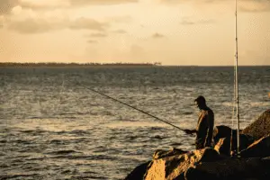 angler fishing at sunset from the shore