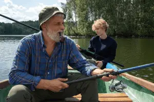 angler and his son fishing from a boat in the lake