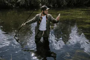 A man fishing in the water with a proper hook for bass.