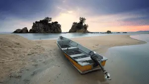 fishing boat left on the shore at sunset