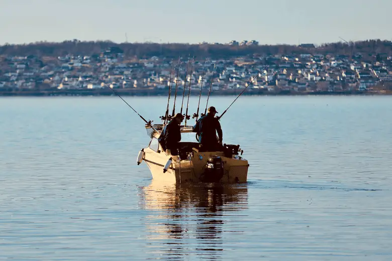 two anglers fishing from a boat in the middle of the lake