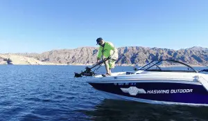 angler on a fishing boat setting up a trolling motor