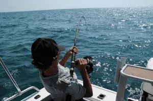 man casting a fishing reel from a boat